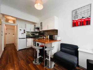 een kleine keuken met een tafel en stoelen in een kamer bij 3-Bed Apartment in King's Cross Central London in Londen