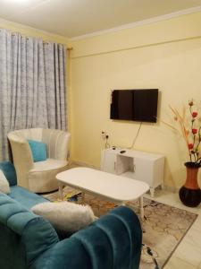 a living room with a couch and a tv at Jabali- Zuriel homes 1 bedroom apartment in Kakamega