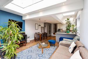 倫敦的住宿－Modern and Spacious Colliers Wood Home，带沙发的客厅和用餐室