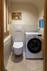 a bathroom with a washing machine and a washer at L'Écrin de Luxe by Les Maisons de Charloc Homes in Branville