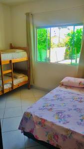 a bedroom with two bunk beds and a window at Gênesis Beach Hostel! Quartos compartilhados e privativos na Pinheira in Palhoça