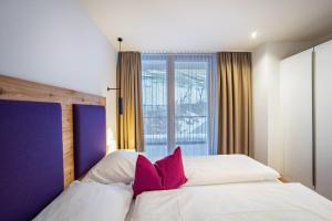 1 Schlafzimmer mit 2 weißen Betten und rosa Kissen in der Unterkunft Stoana Apt 1-1 in San Giacomo