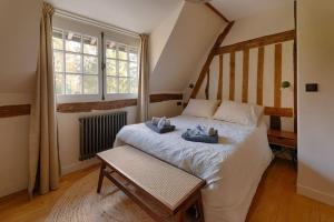 a bedroom with a bed with two teddy bears on it at L'Écrin de Luxe by Les Maisons de Charloc Homes in Branville
