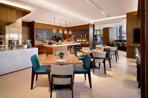 um restaurante com mesas e cadeiras e uma cozinha em Fairfield by Marriott Taichung em Taichung