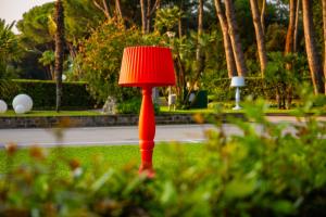 eine rote Lampe im Gras in einem Park in der Unterkunft SMALL CAMP Baia Domizia KR VIP Full Service in Baia Domizia