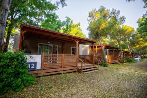 a row of cottages in the woods at SMALL CAMP Baia Domizia KR VIP Full Service in Baia Domizia