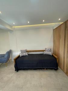 a bedroom with a bed and a blue chair at Patagonia House - Peña in Puerto Madryn
