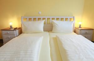 2 Betten mit weißer Bettwäsche und Kissen in einem Zimmer in der Unterkunft Fewo on the Top in Willingen