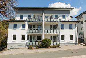 ein weißes Gebäude mit Balkonen an der Seite in der Unterkunft Fewo on the Top in Willingen