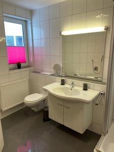 ein Badezimmer mit Waschbecken, Toilette und Spiegel in der Unterkunft Fewo on the Top in Willingen + 5 Fotos