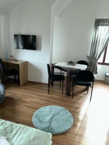 uma sala de estar com uma mesa e cadeiras e uma televisão em Pension Westerhuesen em Magdeburgo