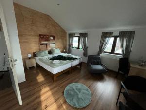 a large bedroom with a bed and a chair at Pension Westerhuesen in Magdeburg +4 photos