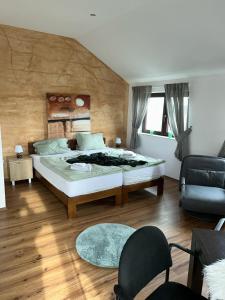 um quarto com uma cama, um sofá e uma cadeira em Pension Westerhuesen em Magdeburgo