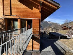 a house with a balcony with a view of the mountains at Chalet Roossi 4 in Wengen