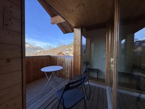a room with a balcony with a table and two chairs at Chalet Roossi 4 in Wengen +5 photos