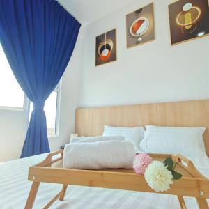 a bedroom with a wooden bed with a blue curtain at Amber Cove Seaview I MUJI 2BR I Game Room I 3-9pax in Malacca