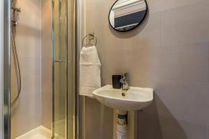 ein Bad mit einem Waschbecken, einem Spiegel und einer Dusche in der Unterkunft Room 01 - Sandhaven Rooms - Double in South Shields