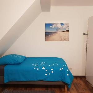 a bedroom with a bed with blue sheets and a beach at FEWO Solingen Abendstrasse in Solingen