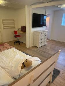 a teddy bear laying on a bed in a bedroom at Hyggeligt gæstehus in Kjellerup