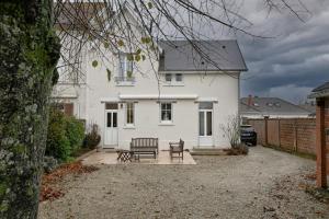 a white house with a table and benches in front of it at Maison de Champagne F.Barbier ! in Avize