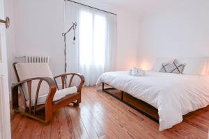 a bedroom with a bed and a chair and a window at Maison de Champagne F.Barbier ! in Avize