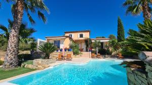 a villa with a swimming pool in front of a house at la cigale sous l'olivier in Le Castellet