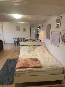 a bed in a room with a dining room at Hyggeligt gæstehus in Kjellerup