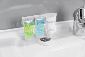 three tubes of moisturizing moisturizers sitting on a bathroom sink at The Marsons Collection - 2 Bedrooms Apartment - Balcony - Secure Parking - 1MC in Birmingham