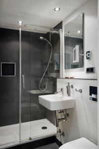 La salle de bains est pourvue d'un lavabo et d'une douche. dans l'établissement Hotel St. Annen, à Hambourg