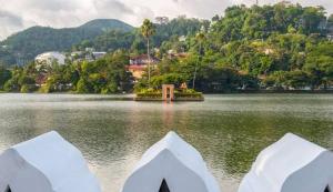 vistas a un lago con árboles y a una ciudad en Sakura hotel and restaurant, en Kandy
