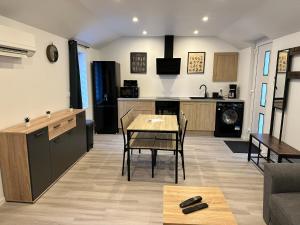 a kitchen and living room with a table and chairs at Chez FanF & Nanie - Maison De Vacances Tout Confort - Proche Plages du Débarquement in Isigny-sur-Mer