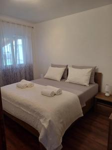 a bedroom with a bed with two towels on it at Apartments Grdelin in Trogir