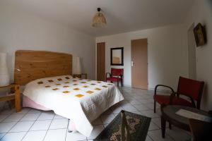 a bedroom with a bed and a table and chairs at chambre indépendante dans le moulin in Pouilly-sur-Vingeanne