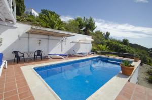 a swimming pool in front of a house at Cortijo Bellavista in Cómpeta