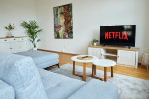a living room with a couch and a tv at IDEE Living: Design-Apartment- Netflix - 6 Pers in Mannheim
