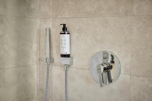 a soap dispenser on the wall of a shower in a bathroom at IDEE Living: Design-Apartment- Netflix - 6 Pers in Mannheim