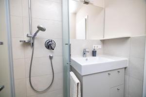 La salle de bains est pourvue d'une douche et d'un lavabo. dans l'établissement Apartment Bellevue Seis, à Alpe di Siusi