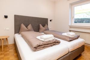 Apartment Bellevue Seis في سويسي: سرير وفوط فوق الغرفة