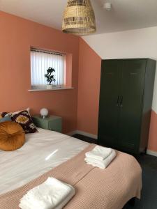 - une chambre avec un lit doté d'armoires vertes et d'une fenêtre dans l'établissement Bridge Square Apartments, à Lancaster