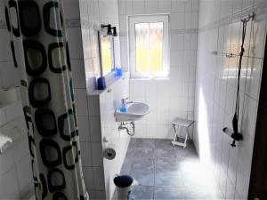 ein weißes Badezimmer mit einem Waschbecken und einem Spiegel in der Unterkunft Hotel Panorama in Wees
