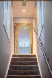 a staircase in a building with a gold framed doorway at AVO Kelham Apartments in Sheffield