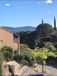 widok na dom z drzewami i budynek w obiekcie CAVALAIRE vue MER au loin MAISONNETTE TOUT ÉQUIPÉE POUR 4 PERSONNES AVEC PISCINE CLIM WIFI VÉLOS TV BARBECUES w mieście Cavalaire-sur-Mer