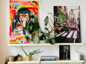 a shelf with plants and a painting of a monkey at Down-Town 1 Bedroom Flat in Brussels