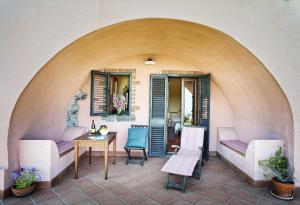 een patio met 2 banken en een tafel en stoelen bij Agriturismo Tenuta San Michele in Santa Venerina