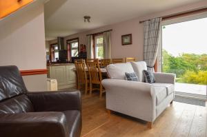 un salon avec un canapé et une chaise dans l'établissement Larch Cottage, à Blairmore