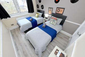 een kleine slaapkamer met 2 bedden en een raam bij SUPERB 4 BEDROOM FLAT in THE HEART OF CAMDEN TOWN in Londen