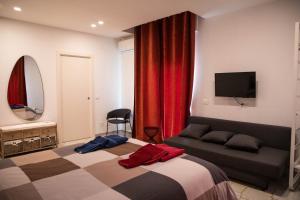 1 dormitorio con cama, sofá y TV en Dimore Dalle Zie, en Alberobello