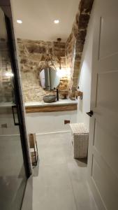 a hallway with a kitchen with a stone wall at Cal Rei in Grañena de Cervera