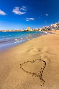 a heart drawn in the sand on a beach at Mi casita Tenerife Sur Free WIFI e AC in Arona