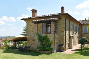 una vista esterna di una casa in pietra con patio di Agriturismo Borgo Sant'Ercolano a Ciggiano